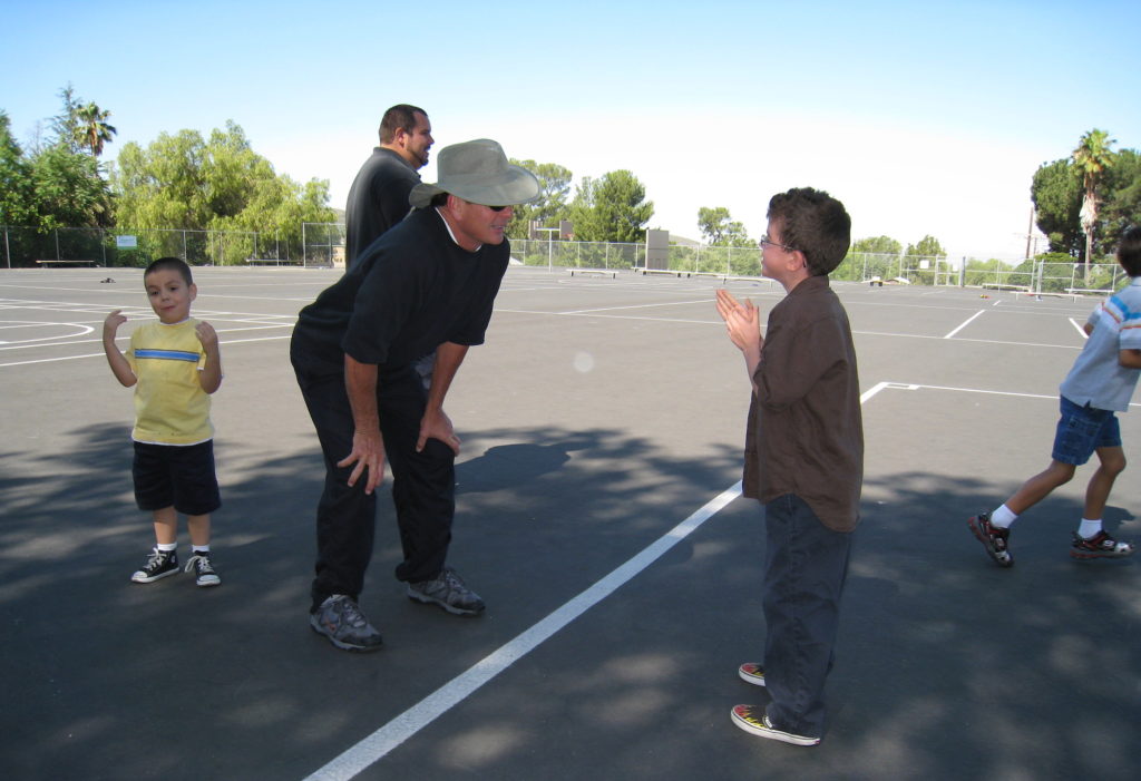 Nine year old Dylan Harvey speaks with his adaptive physical education teacher during class.