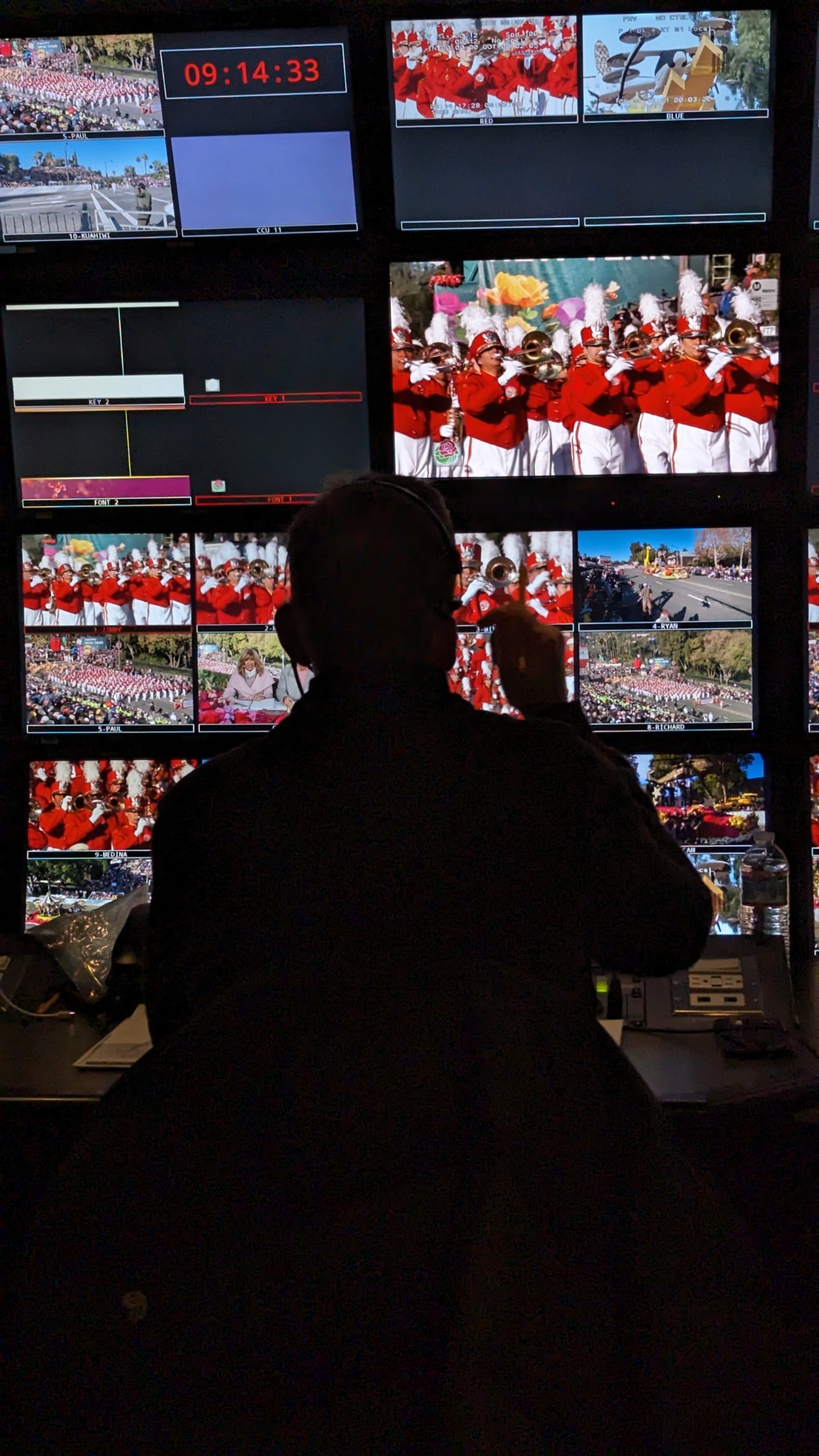 Close-up view inside KTLA's 2024 Rose Parade broadcast control room, showing production personnel working at consoles.