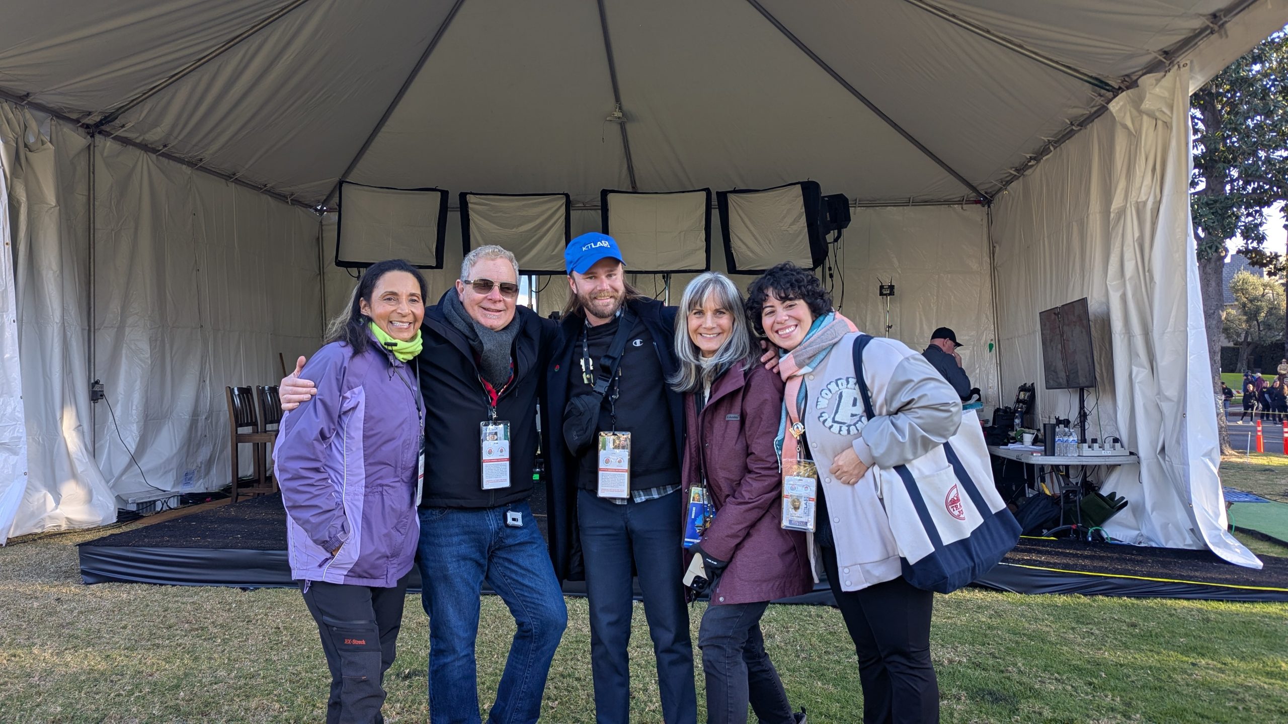 Patricia Nazario posing with fellow KTLA field producers and the line producer beneath a production tent during the 2025 Rose Parade.